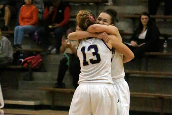 Senior Aries Washington embraces her teammate  after she scored her 1,000th career point as a Hornet basketball player.