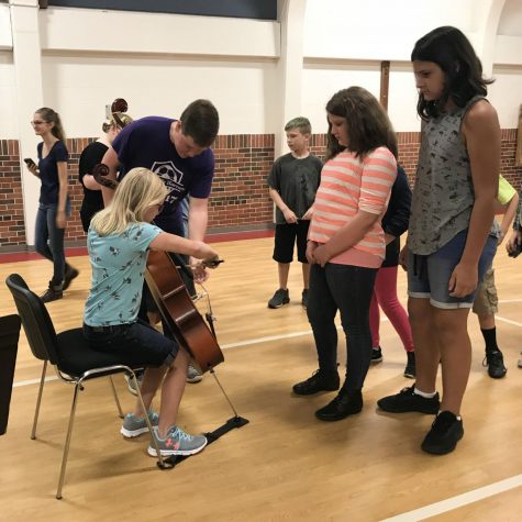 Introducing Music. On August 24th Hornet Orchestra seniors toured elementary schools. Senior Shane Beshears introduces the cello to a fifth grader during the instrument demonstration. 
